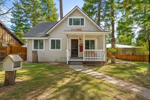 A single-story house with a front porch, a mailbox, and a wooden fence.