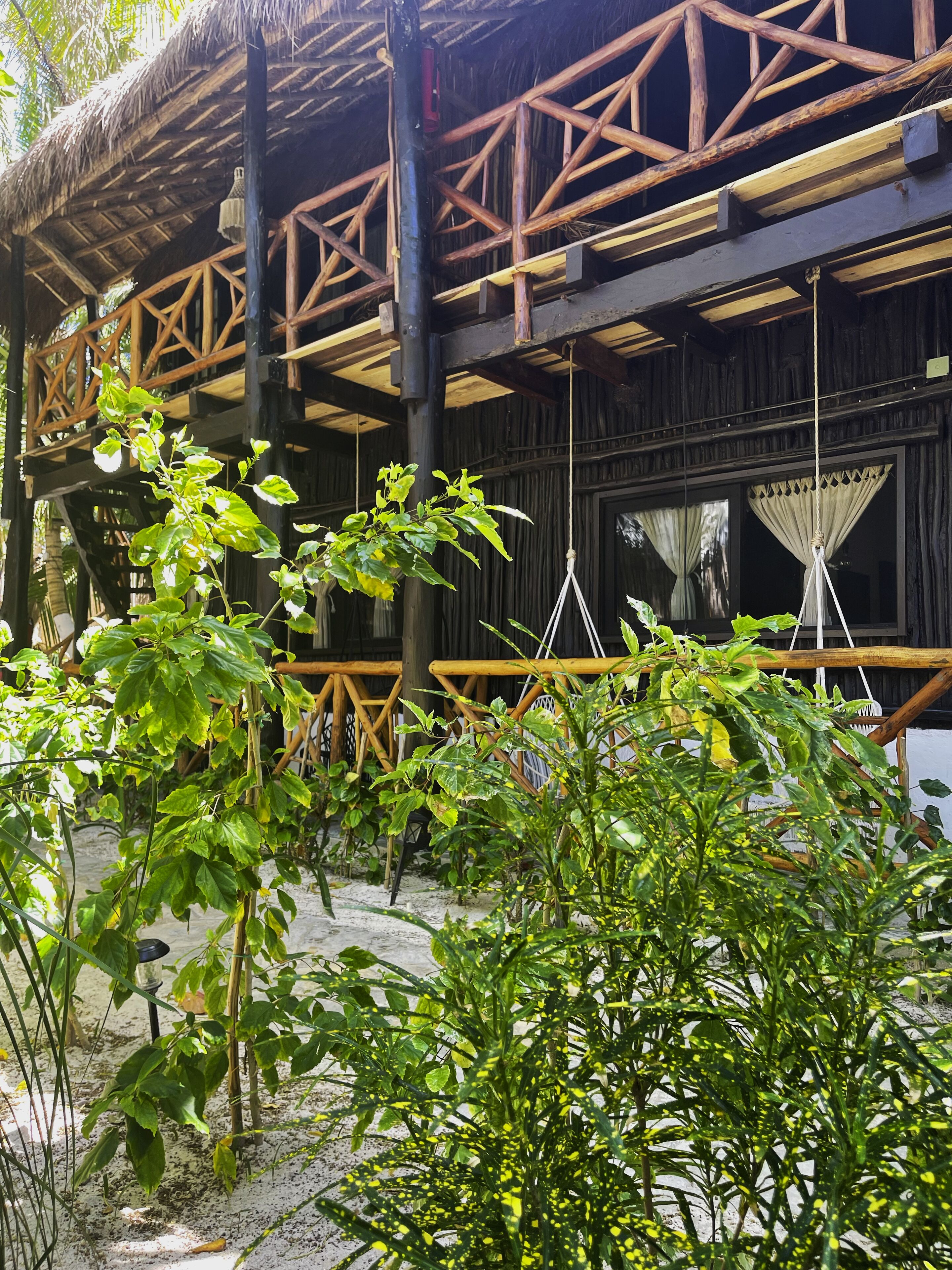 A rustic wooden structure with a thatched roof and a balcony.