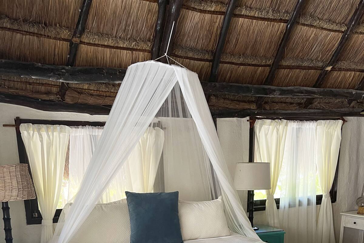 A bed with a canopy, a nightstand, and a lamp.