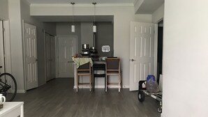 A spacious kitchen with a dining area, wooden chairs, a small table, and a bicycle in the foreground. - Two bedroom apartment with lots of light (Atlanta)