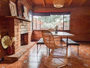 Enjoy meals by the fireplace in this charming dining area with a view of the outdoors.