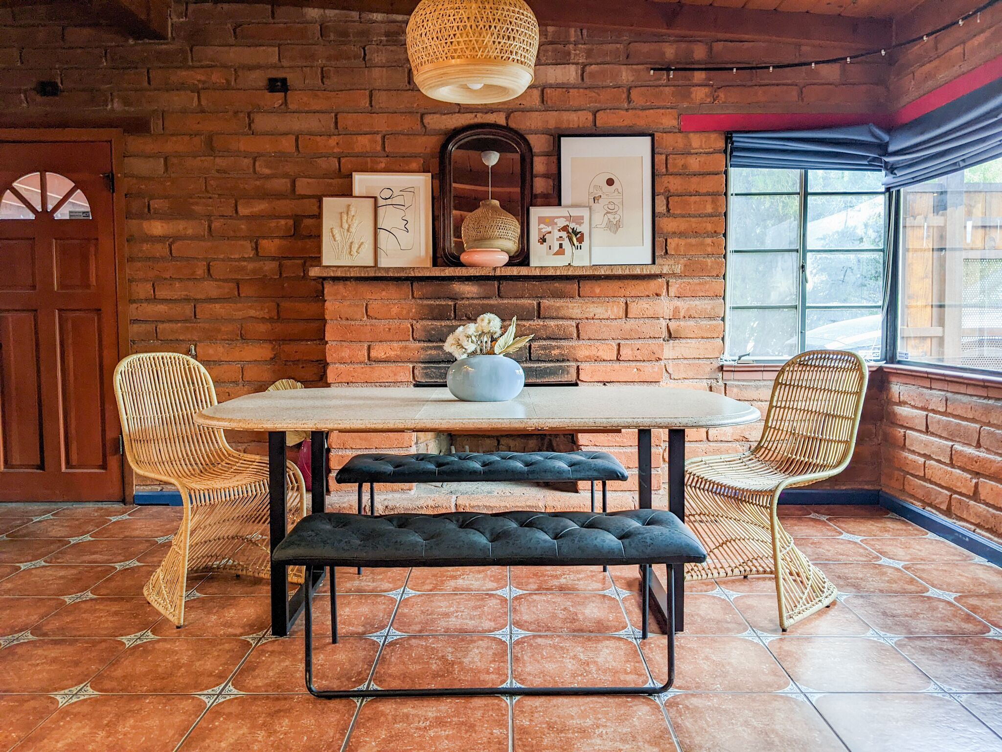 Un comedor acogedor con pared de ladrillo, una mesa redonda y sillas de mimbre.