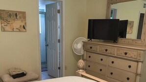 A bedroom with a bed, dresser, mirror, and a fan. - Recently Remodeled, Very Comfy Condo Near Disney, Universal and Sea World. (Kissimmee)
