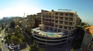 A multi-story hotel with a rooftop pool and balconies. - Hotel Le Crillon (Broumana)
