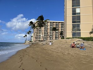 A beach with a high-rise hotel in the background. - Direct OCEANFRONT STUDIO CONDO (Lahaina)