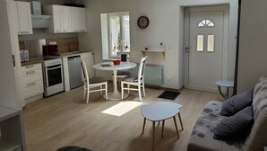 A compact living space with a kitchenette, a dining area, and a sofa.