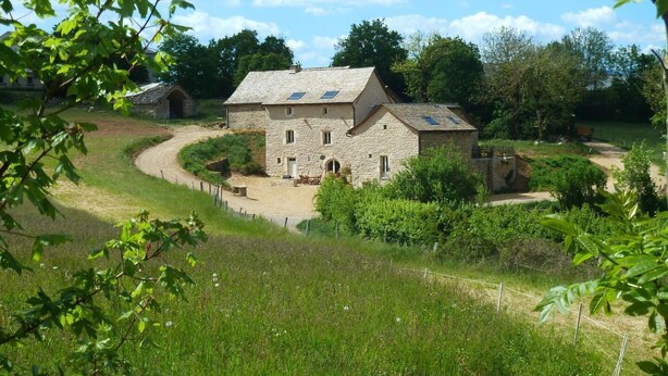 A stone farmhouse with a dirt path leading to the entrance, surrounded by greenery and trees. - Gîte "La Prairie" - LA CANOURGUE (LA CANOURGUE)