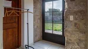 A room with a wooden door, a black-framed window, and a tiled floor.
