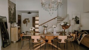 Un coin repas avec une table et des chaises en bois, agrémenté de vases décoratifs et d’un lustre.