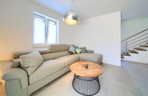 Relax in this stylish living room with a comfortable sofa, coffee table, and large window.