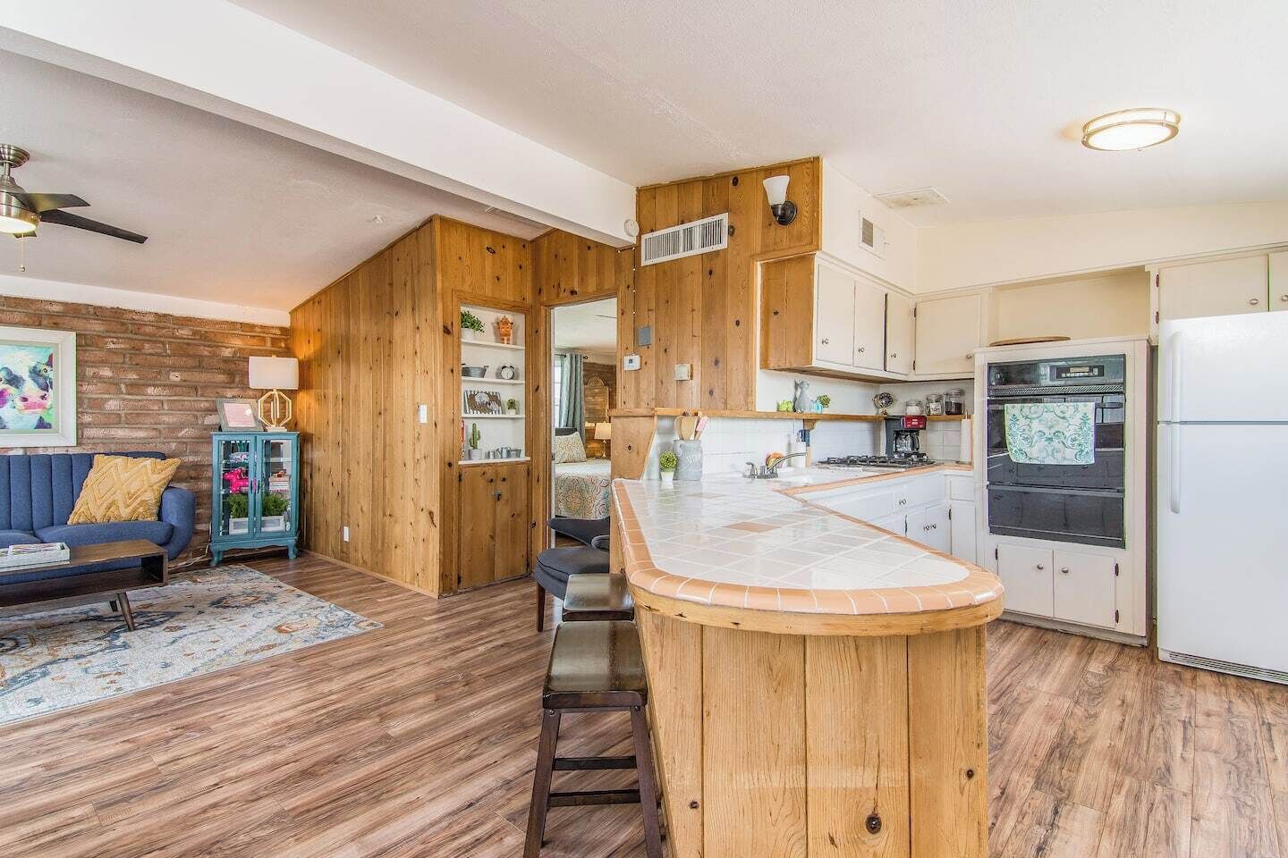 A compact kitchen with wooden cabinets, a built-in stove, and a refrigerator.