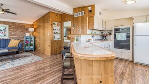 Una cocina compacta con armarios de madera, estufa integrada y refrigerador.