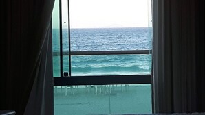 Um quarto com uma janela grande com vista para o oceano.