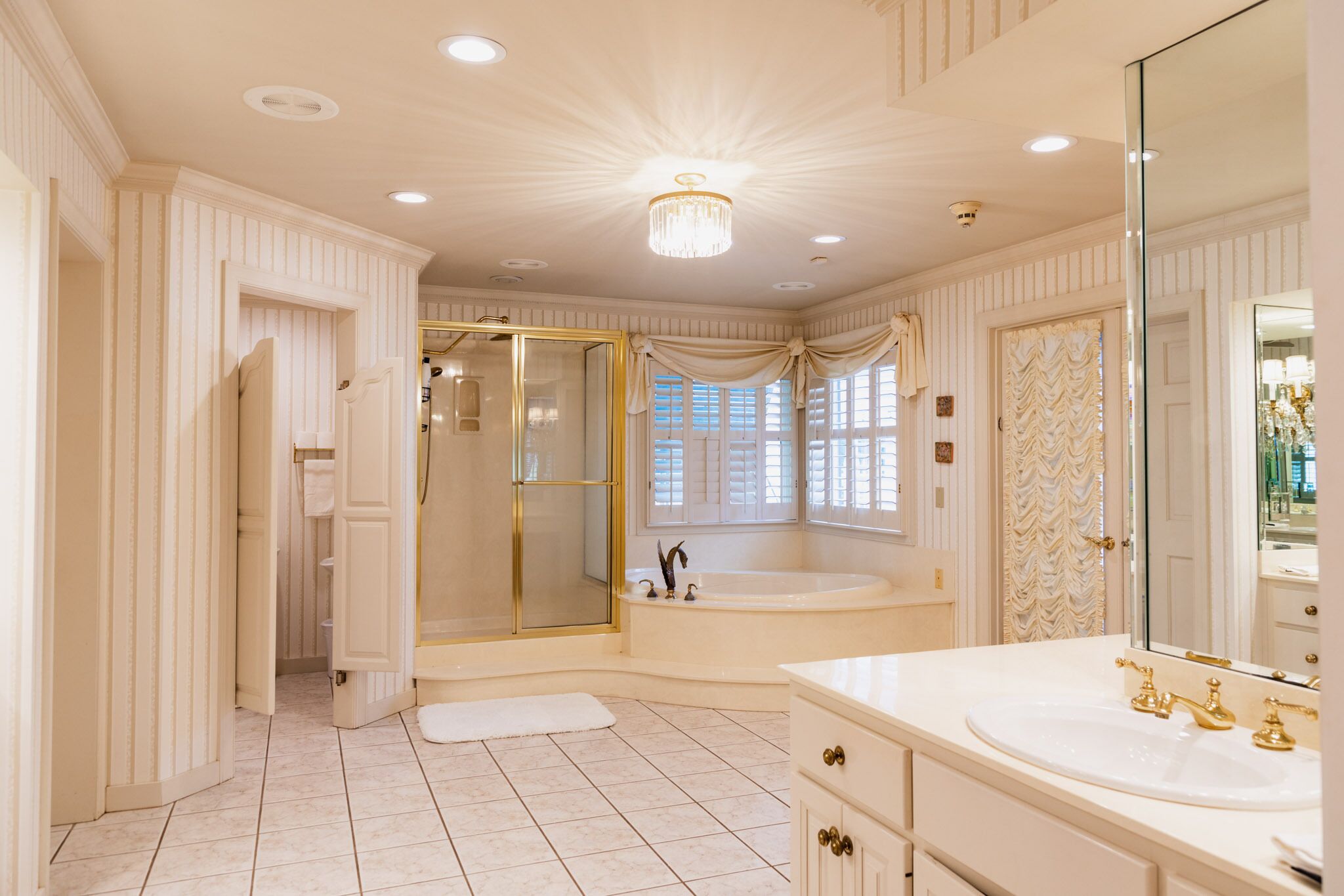 A spacious bathroom with a large bathtub, a walk-in shower, and a vanity with a large mirror.