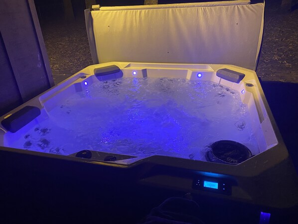 Un jacuzzi con panel de control digital e iluminación azul.