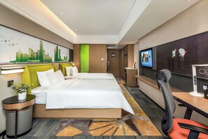 Ein Hotelzimmer mit zwei Betten, einem Schreibtisch mit Stuhl, einem Fernseher und einem an der Wand befestigten Bildschirm.