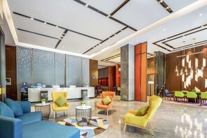 Eine moderne Lobby mit Empfangstresen, Sitzbereichen und einer Wandgestaltung.