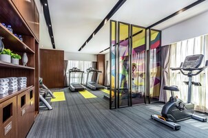 A modern hotel gym with treadmills, an elliptical, and a stationary bike.