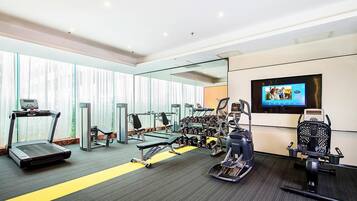 A gym with treadmills, elliptical machines, and free weights.