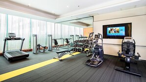 A gym with treadmills, elliptical machines, and free weights.