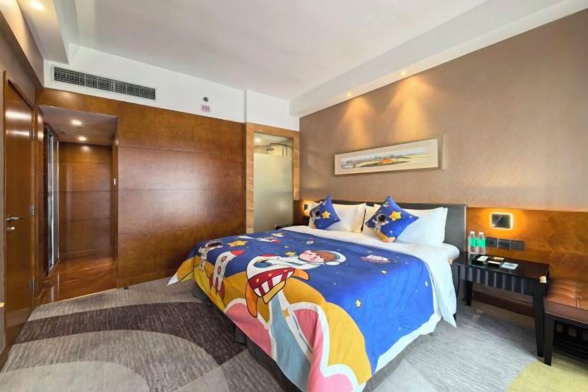 Una habitación de hotel con una cama, una mesita de noche y un velador.
