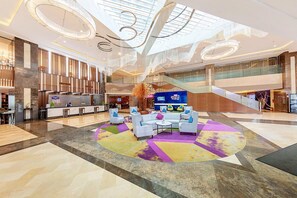 A spacious lobby with a central seating area, a reception desk, and a staircase leading to upper levels. - Hampton By Hilton Zhuhai Gongbei Port (Zhuhai)