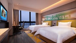 Een hotelkamer met twee bedden, een bureau en een televisie.