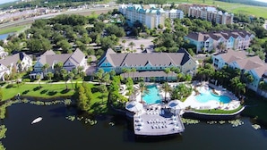 A resort with a central pool, multiple guest buildings, and a dock area. - Lake view gorgeous condo 3bd - 10 min from Disney (Kissimmee)