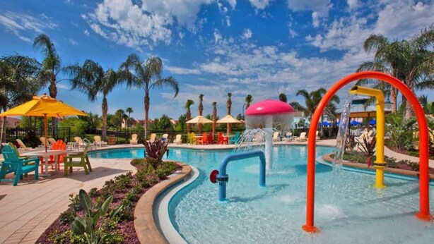 A pool area with a water slide, lounge chairs, and umbrellas. - Lake view gorgeous condo 3bd - 10 min from Disney (Kissimmee)