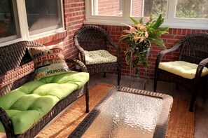 Relax in this inviting space with a sofa, two chairs, and a potted plant.