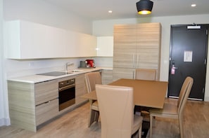 Enjoy meals in the kitchen with an oven and dining area featuring a wooden table and four chairs.