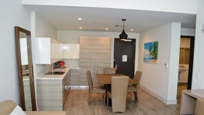 A modern apartment with a dining area, kitchen, and a living room with a sofa. - CH Luxury Condo|Accessible|Partial Ocean View-CS5 (Hollywood)