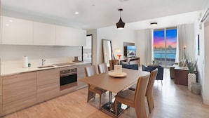 A modern hotel room with a kitchen, dining area, and a large window with a city view. - Luxury Waterfront Condo w/ Stunning Sunset View-CS36 (Hollywood)
