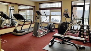 A gym with treadmills, elliptical machines, and weightlifting equipment. - Unit 312 1 BD/ 1 BA Condo (Birchwood)