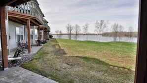 A lakeside property with a covered patio, outdoor seating, and a view of the lake. - Unit 312 1 BD/ 1 BA Condo (Birchwood)