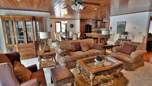 A spacious living room with a large sofa set, a coffee table, and a dining area with chairs and a table. - Peace of Mind on Namakagon (Cable)