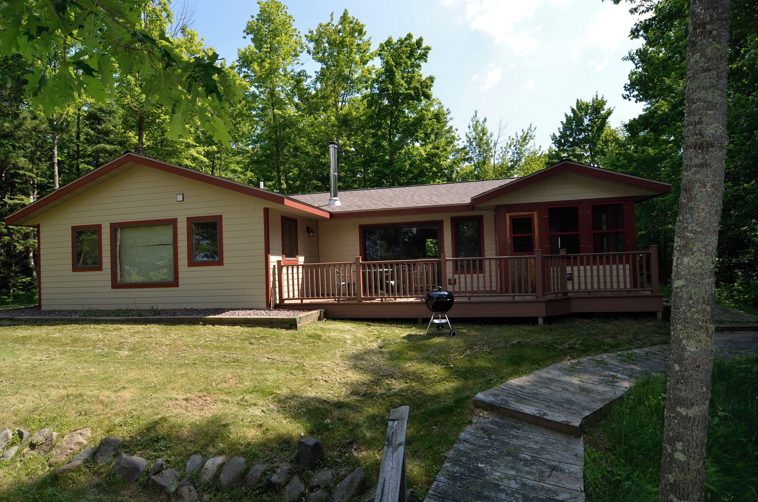 A two-story house with a deck and a chimney.
