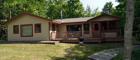 A two-story house with a deck and a chimney.