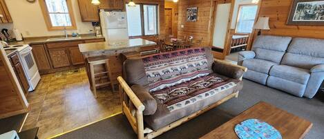 A cozy living room with a sofa, a wooden coffee table, and a dining area with a table and chairs.