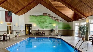 An indoor swimming pool with a wooden ceiling, a mural of a landscape, and a flag. - Unit 311 1 BD/ 1 BA Condo (Birchwood)