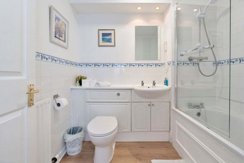 A bathroom with a toilet, sink, and shower.