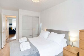Une chambre d’hôtel avec un lit, des tables de chevet et une armoire.