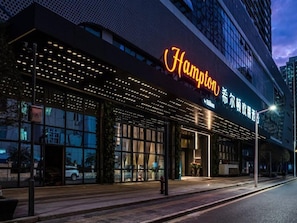 A hotel with a prominent 'Hampton' sign, large windows, and a modern facade.