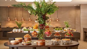Ein reichhaltiges Buffet mit verschiedenen Speisen und einer zentralen Blumenkomposition.