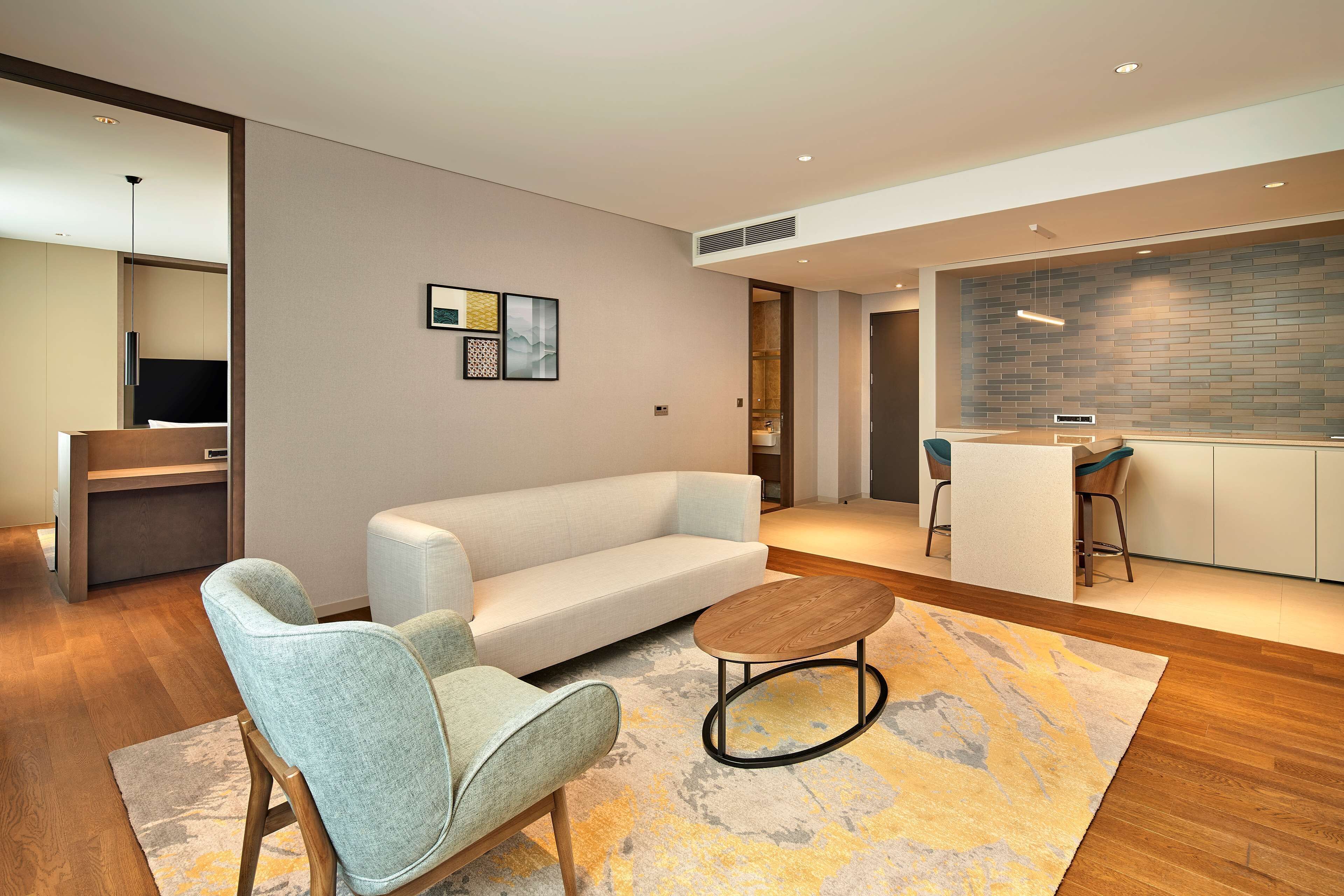 Una sala de estar moderna con sofá, mesa de centro y televisor.