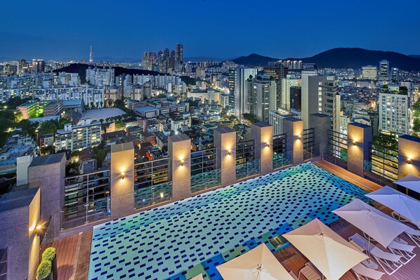 Una piscina al aire libre, tumbonas, socorrista en las instalaciones