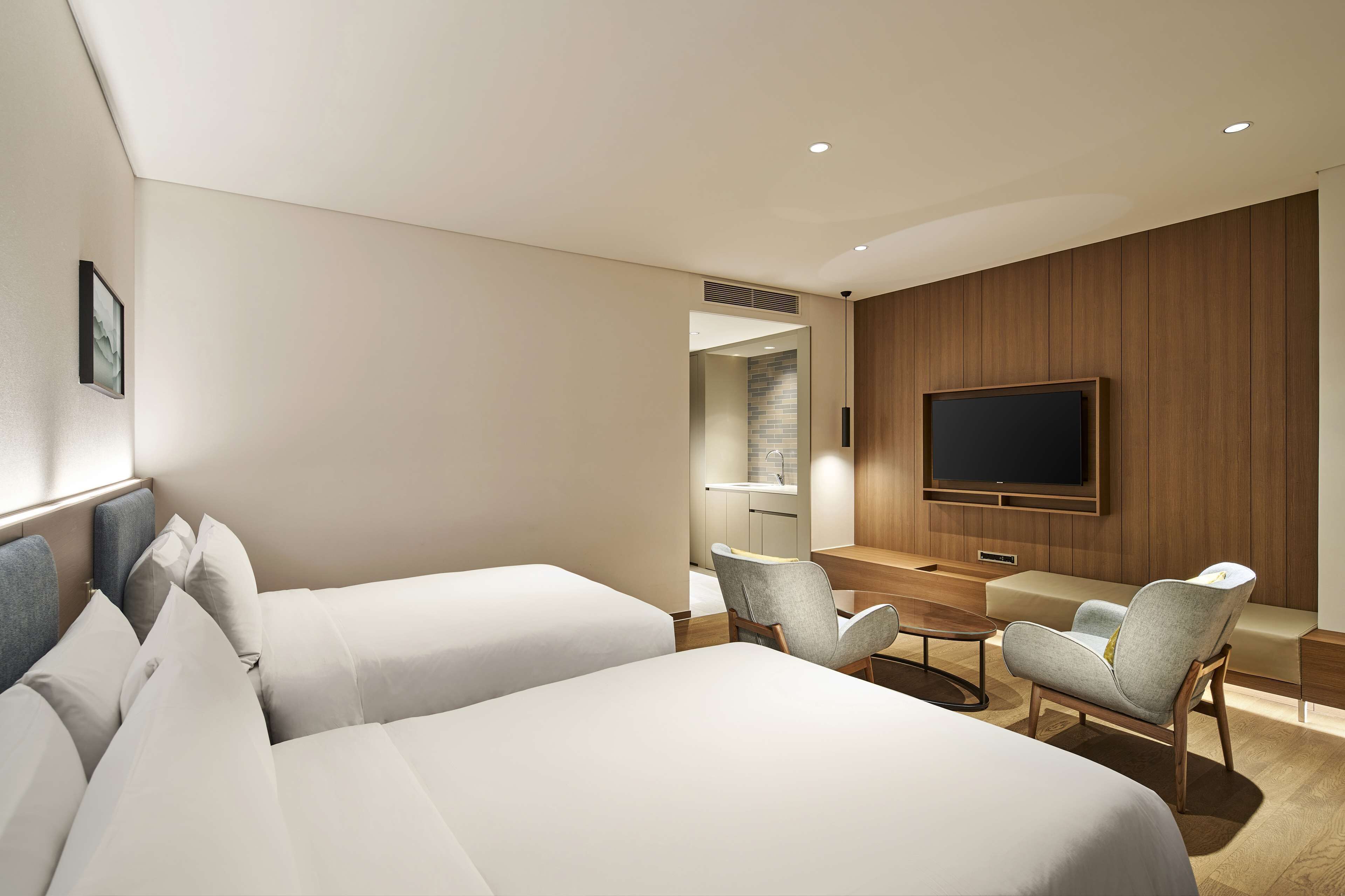 Ett hotellrum med två sängar, en TV, ett skrivbord och en sittgrupp.