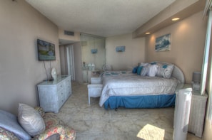 A bedroom with a bed, dresser, chair, and a mirror.
