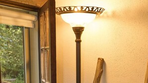 A room with a window, a standing lamp, a wooden ladder, and a plaid blanket. - Charming, historic, Creekside Cabin nestled at the base of Pikes Peak in Cascade (Cascade,)