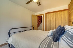 Ein Schlafzimmer mit einem Bett, einer Holztür und einer Treppe, die in einen oberen Bereich führt.